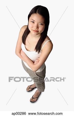 Young woman looking at camera, arms crossed View Large Photo Image Stock Photograph - Young woman looking at camera, arms crossed. Fotosearch