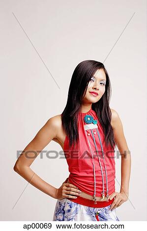 Young woman looking at camera, hands on hip View Large Photo Image Stock Photo - Young woman looking at camera, hands on hip. Fotosearch