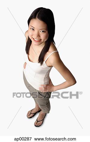 Stock Photo - Young woman looking at camera, hands on hips. Fotosearch