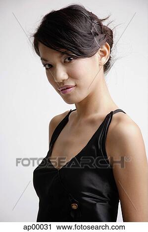 Stock Image - Young woman looking at camera, portrait. Fotosearch