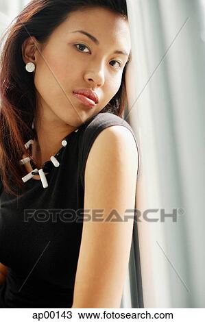 Stock Image - Young woman looking at camera, portrait. Fotosearch