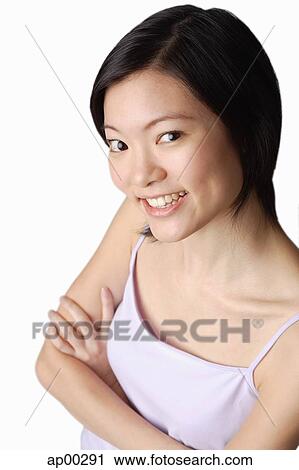 Young woman looking at camera, smiling, arms crossed View Large Photo Image Stock Image - Young woman looking at camera, smiling, arms crossed. Fotosearch