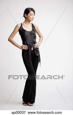 Stock Photo - Young woman looking away, hands on hips. Fotosearch