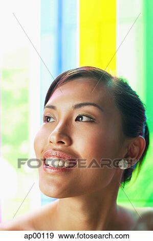 Stock Photo - Young woman looking away, head shot. Fotosearch