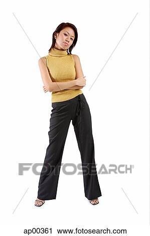 Stock Image - Young woman standing, arms crossed. Fotosearch