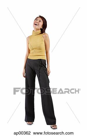 Stock Image - Young woman standing, looking up. Fotosearch