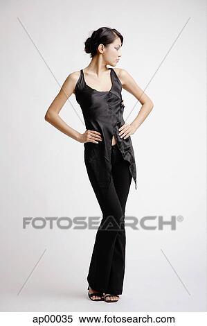 Young woman standing with hands on hips, looking away View Large Photo Image Stock Photography - Young woman standing with hands on hips, looking away. Fotosearch