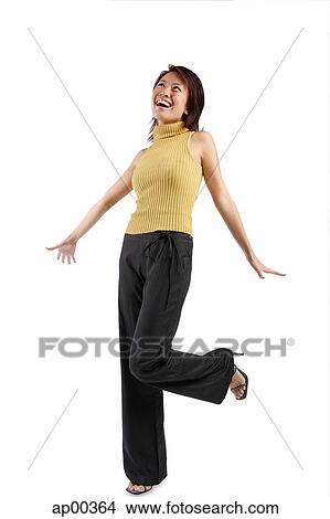 Young woman standing with one leg up, looking away View Large Photo Image Picture - Young woman standing with one leg up, looking away. Fotosearch