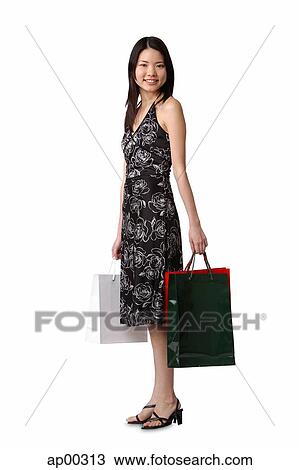 Young woman standing with shopping bags, portrait View Large Photo Image Stock Image - Young woman standing with shopping bags, portrait. Fotosearch