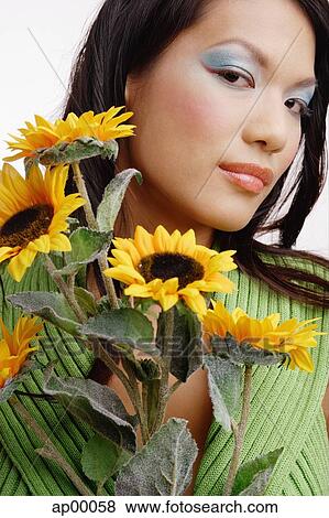 Young woman, with bouquet of flowers, looking at camera View Large Photo Image Stock Photo - Young woman, with bouquet of flowers, looking at camera. Fotosearch