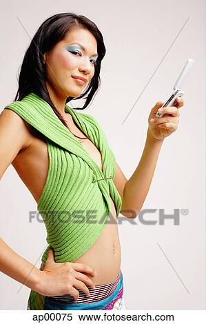 Young woman with mobile phone, hand on hip, looking at camera View Large Photo Image Stock Photography - Young woman with mobile phone, hand on hip, looking at camera. Fotosearch