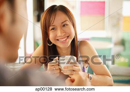 Young woman with mug facing another person, over the shoulder view View Large Photo Image Stock Photo - Young woman with mug facing another person, over the shoulder view. Fotosearch