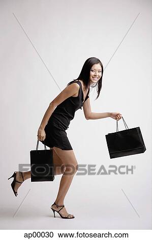 Stock Image - Young woman with shopping bags. Fotosearch