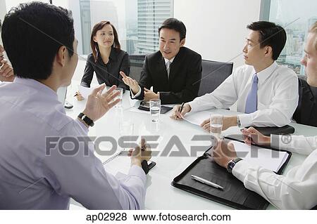 Picture - Executives having a discussion around conference table. Fotosearch - Search Stock Photos, Images, Print Photographs, and Photo Clip Art