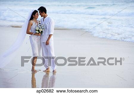 Bride and groom on beach, standing face to face View Large Photo Image Stock Image - Bride and groom on beach, standing face to face. Fotosearch