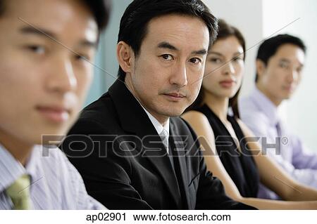 Business people in a row, looking at camera, focus on mature adult View Large Photo Image Stock Image - Business people in a row, looking at camera, focus on mature adult . Fotosearch
