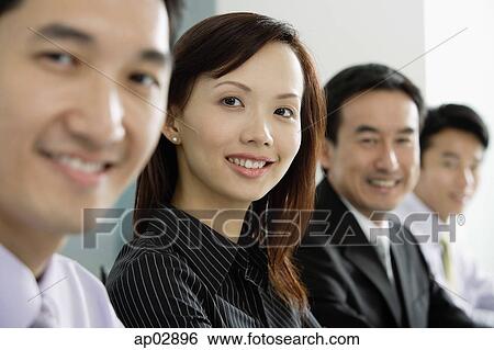 Business people in a row, looking at camera, smiling View Large Photo Image Stock Photograph - Business people in a row, looking at camera, smiling . Fotosearch
