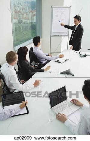 Businessman giving presentation, pointing at whiteboard View Large Photo Image Stock Photo - Businessman giving presentation, pointing at whiteboard . Fotosearch