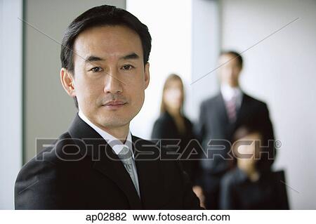 Stock Image - Businessman, portrait, people in the background . Fotosearch