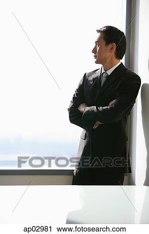 Businessman standing next to window, looking out, side view View Large Photo Image Stock Image - Businessman standing next to window, looking out, side view . Fotosearch