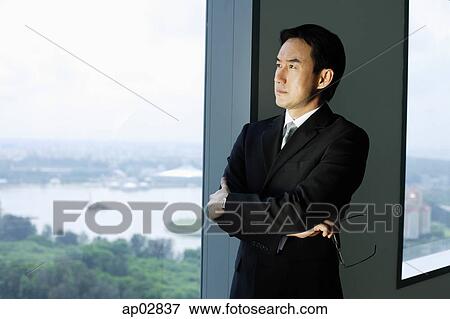 Businessman standing next to window, looking out View Large Photo Image Stock Photo - Businessman standing next to window, looking out . Fotosearch