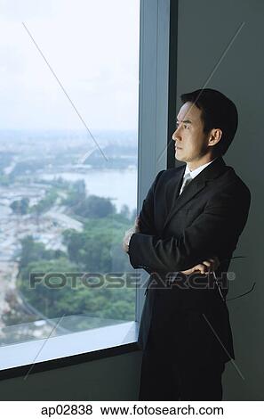 Businessman standing next to window, arms crossed View Large Photo Image Stock Photo - Businessman standing next to window, arms crossed . Fotosearch