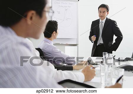 Businessman talking to executives in meeting View Large Photo Image Stock Image - Businessman talking to executives in meeting . Fotosearch