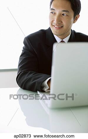 Businessman with laptop, looking away View Large Photo Image Stock Image - Businessman with laptop, looking away . Fotosearch