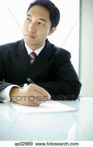 Businessman with pen and paper, looking away View Large Photo Image Stock Photo - Businessman with pen and paper, looking away . Fotosearch