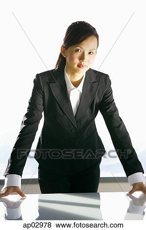 Businesswoman leaning on table, looking at camera View Large Photo Image Stock Photo - Businesswoman leaning on table, looking at camera . Fotosearch