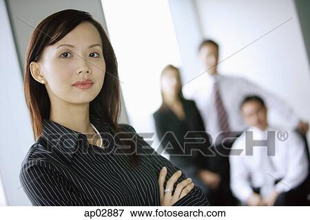 Businesswoman, looking at the camera, people in the background View Large Photo Image Stock Photo - Businesswoman, looking at the camera, people in the background . Fotosearch