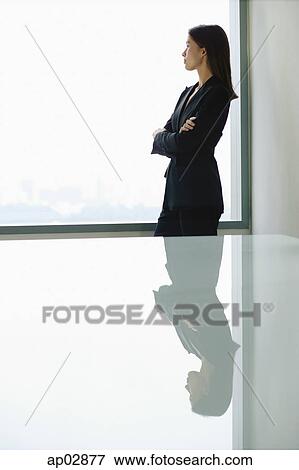 Businesswoman standing with arms crossed, looking at window View Large Photo Image Stock Photo - Businesswoman standing with arms crossed, looking at window . Fotosearch