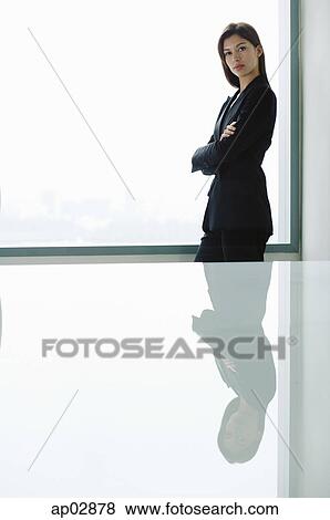 Stock Photo - Businesswoman standing with arms crossed, looking at camera . Fotosearch