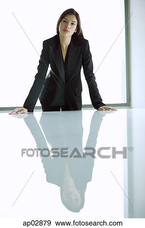 Businesswoman standing with hands on table, looking at camera View Large Photo Image Stock Photo - Businesswoman standing with hands on table, looking at camera . Fotosearch