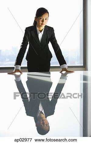 Businesswoman standing with hands on table, looking at camera View Large Photo Image Stock Photo - Businesswoman standing with hands on table, looking at camera . Fotosearch