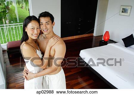 Couple embracing in bedroom, looking at camera View Large Photo Image Stock Photo - Couple embracing in bedroom, looking at camera. Fotosearch