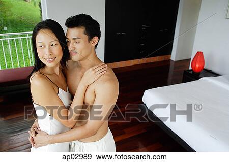 Couple embracing in bedroom, looking away View Large Photo Image Stock Photo - Couple embracing in bedroom, looking away. Fotosearch