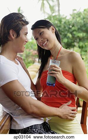 Couple embracing, woman holding drink View Large Photo Image Picture - Couple embracing, woman holding drink . Fotosearch