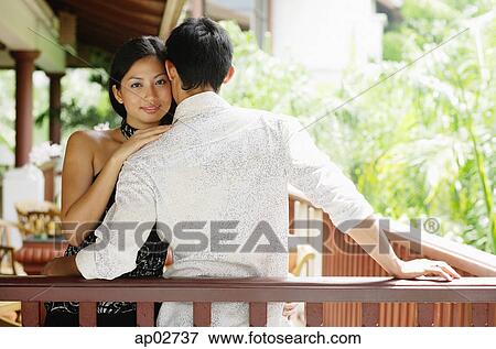 Couple embracing, woman resting head on mans shoulder, looking at camera View Large Photo Image Stock Photo - Couple embracing, woman resting head on mans shoulder, looking at camera . Fotosearch
