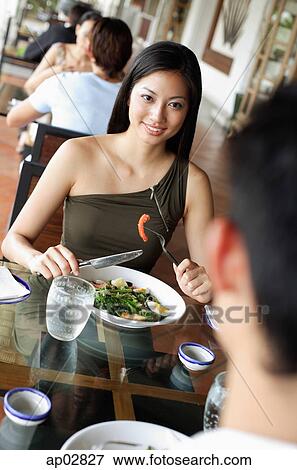 Couple having a meal in restaurant, woman smiling View Large Photo Image Stock Photo - Couple having a meal in restaurant, woman smiling . Fotosearch