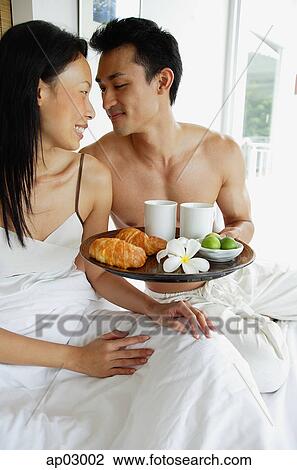Couple having breakfast in bed, looking at each other View Large Photo Image Stock Image - Couple having breakfast in bed, looking at each other . Fotosearch