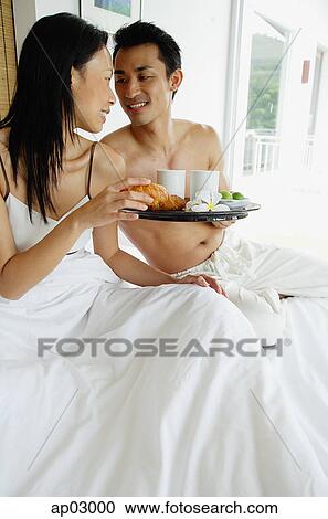 Couple having breakfast in bed, man holding tray View Large Photo Image Stock Image - Couple having breakfast in bed, man holding tray . Fotosearch