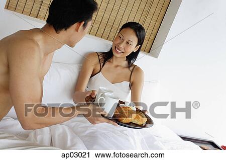 Couple having breakfast in bed View Large Photo Image Stock Image - Couple having breakfast in bed . Fotosearch