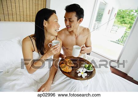 Couple having breakfast in bed View Large Photo Image Stock Photograph - Couple having breakfast in bed . Fotosearch