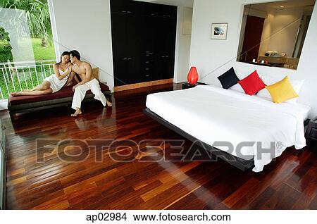 Couple in bedroom, sitting on daybed View Large Photo Image Picture - Couple in bedroom, sitting on daybed . Fotosearch