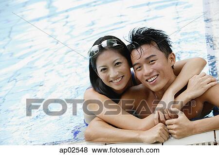 Couple in swimming pool, embracing, looking at camera View Large Photo Image Stock Photo - Couple in swimming pool, embracing, looking at camera. Fotosearch