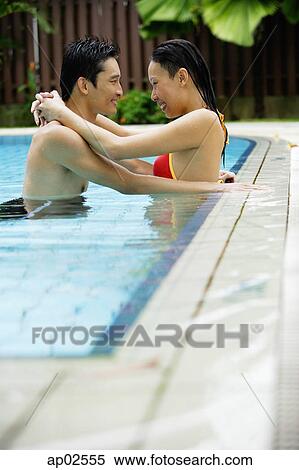 Stock Photography - Couple in swimming pool, embracing . Fotosearch