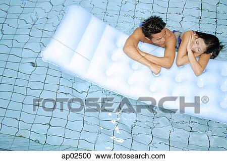 Couple in swimming pool leaning on pool raft, side by side View Large Photo Image Stock Image - Couple in swimming pool leaning on pool raft, side by side . Fotosearch