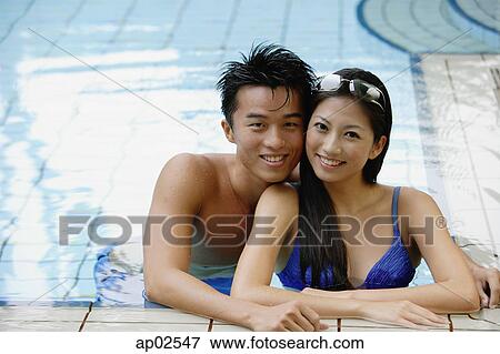 Couple in swimming pool looking at camera View Large Photo Image Stock Photo - Couple in swimming pool looking at camera . Fotosearch