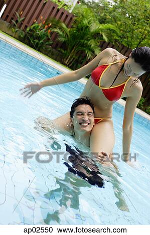 Couple in swimming pool, woman sitting on mans shoulders View Large Photo Image Stock Image - Couple in swimming pool, woman sitting on mans shoulders . Fotosearch